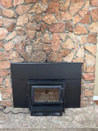 A fireplace with a stone wallAI-generated content may be incorrect.