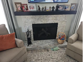 A fireplace with a tv and a chairAI-generated content may be incorrect.