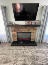 A fireplace with a flat screen tv above itAI-generated content may be incorrect.