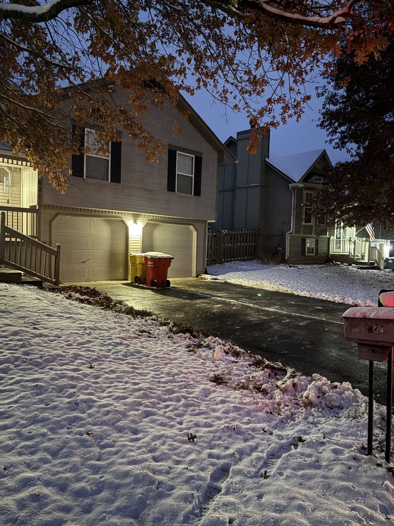 Residential driveway cleared of snow and ice at night after snow removal service by Marrs Lawn and Landscape in Grain Valley, MO.