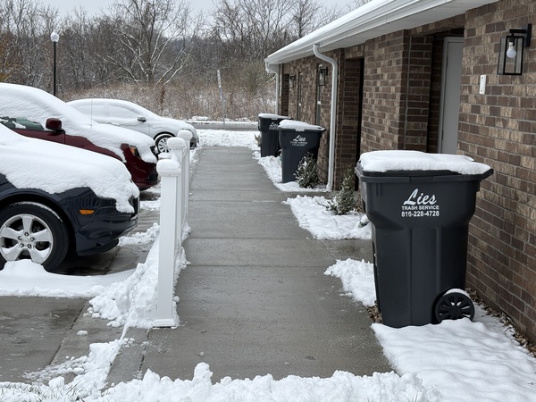 Cleared sidewalk with snow piled to the sides after snow removal service by Marrs Lawn and Landscape in Grain Valley, MO.