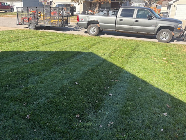 Freshly mowed residential lawn with clean stripes and truck visible, serviced by Marrs Lawn and Landscape in Grain Valley, MO.