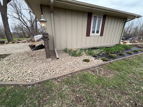 Freshly edged and rock-mulched landscape bed along a residential shed, refreshed by Marrs Lawn and Landscape in Grain Valley, MO.