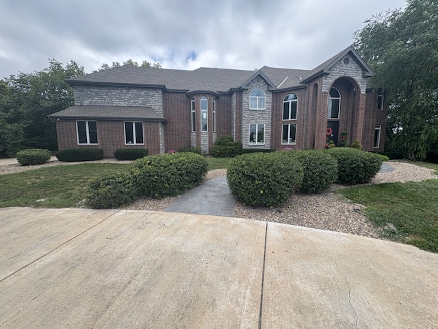 Neatly trimmed shrubs along the front of a home in Grain Valley, MO serviced by Marrs Lawn and Landscape