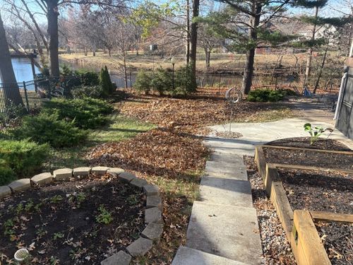 Cleared flower bed and walkway border with exposed mulch after fall leaf blowout by Marrs Lawn and Landscape