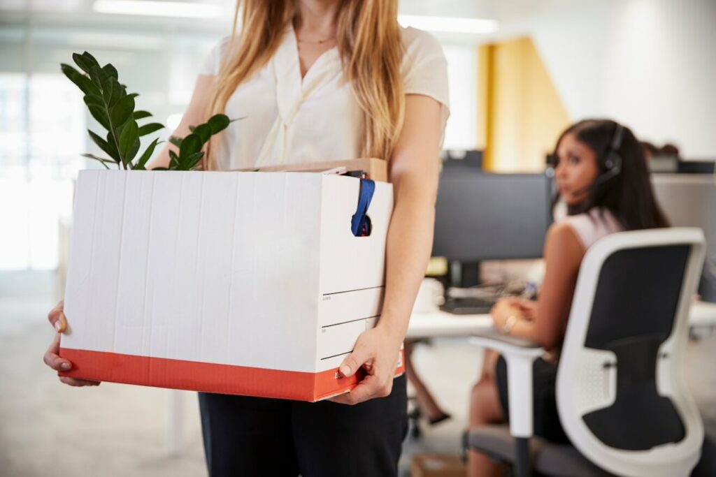 Female employee clearing her desk after resigning from job role.