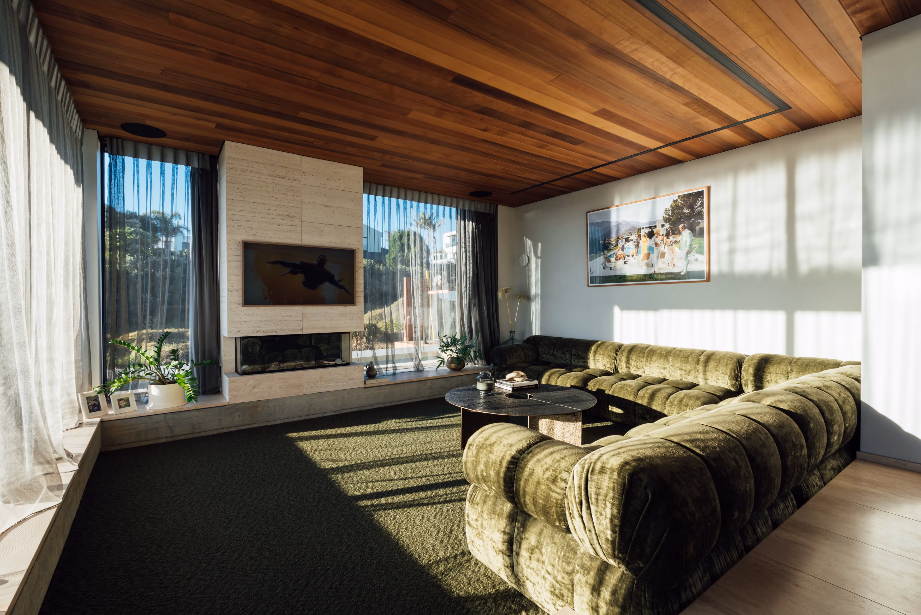 Modern open-plan living area with exposed timber ceiling beams and large windows in a Stewart Construction home