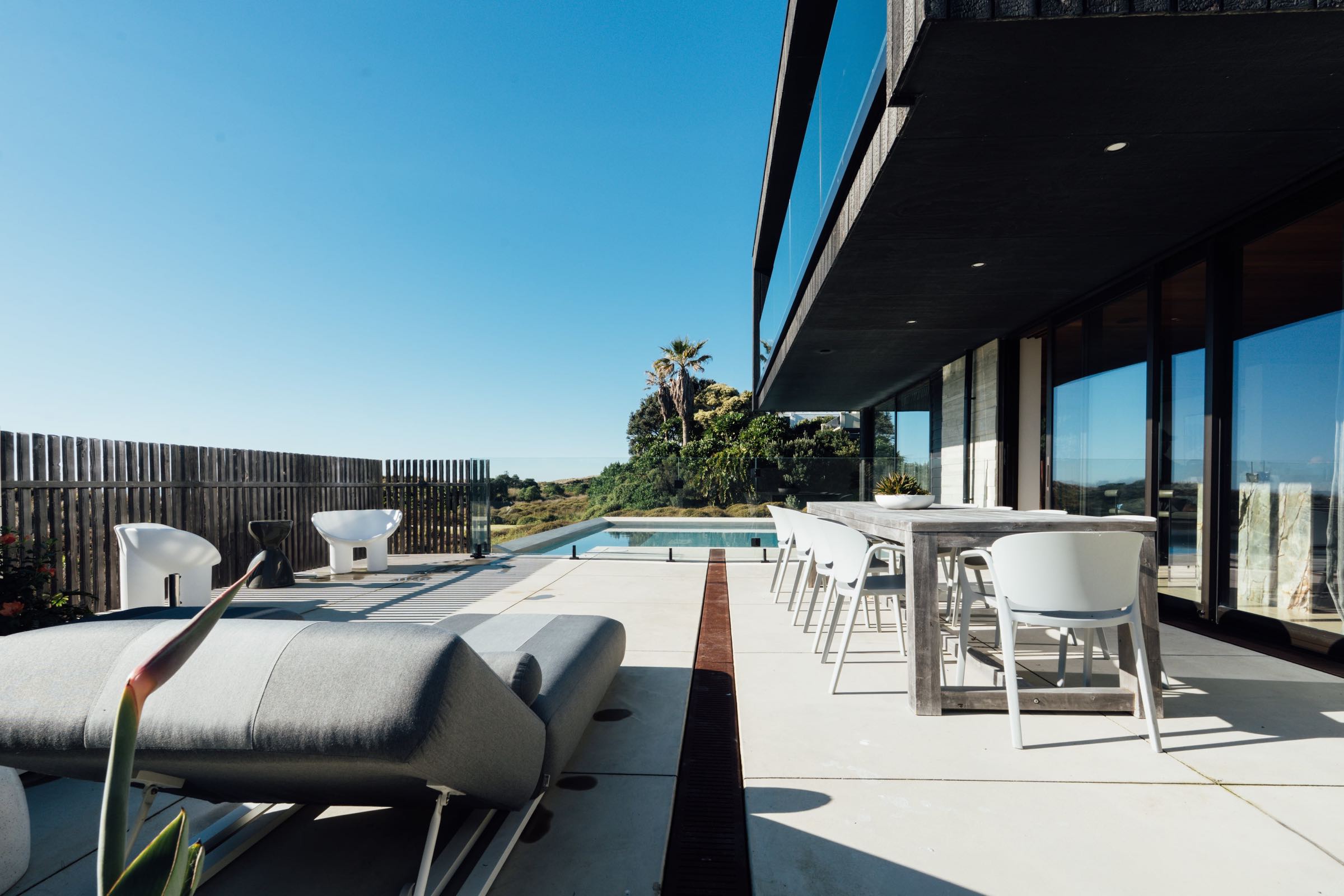 New coastal home with pool terrace at dusk