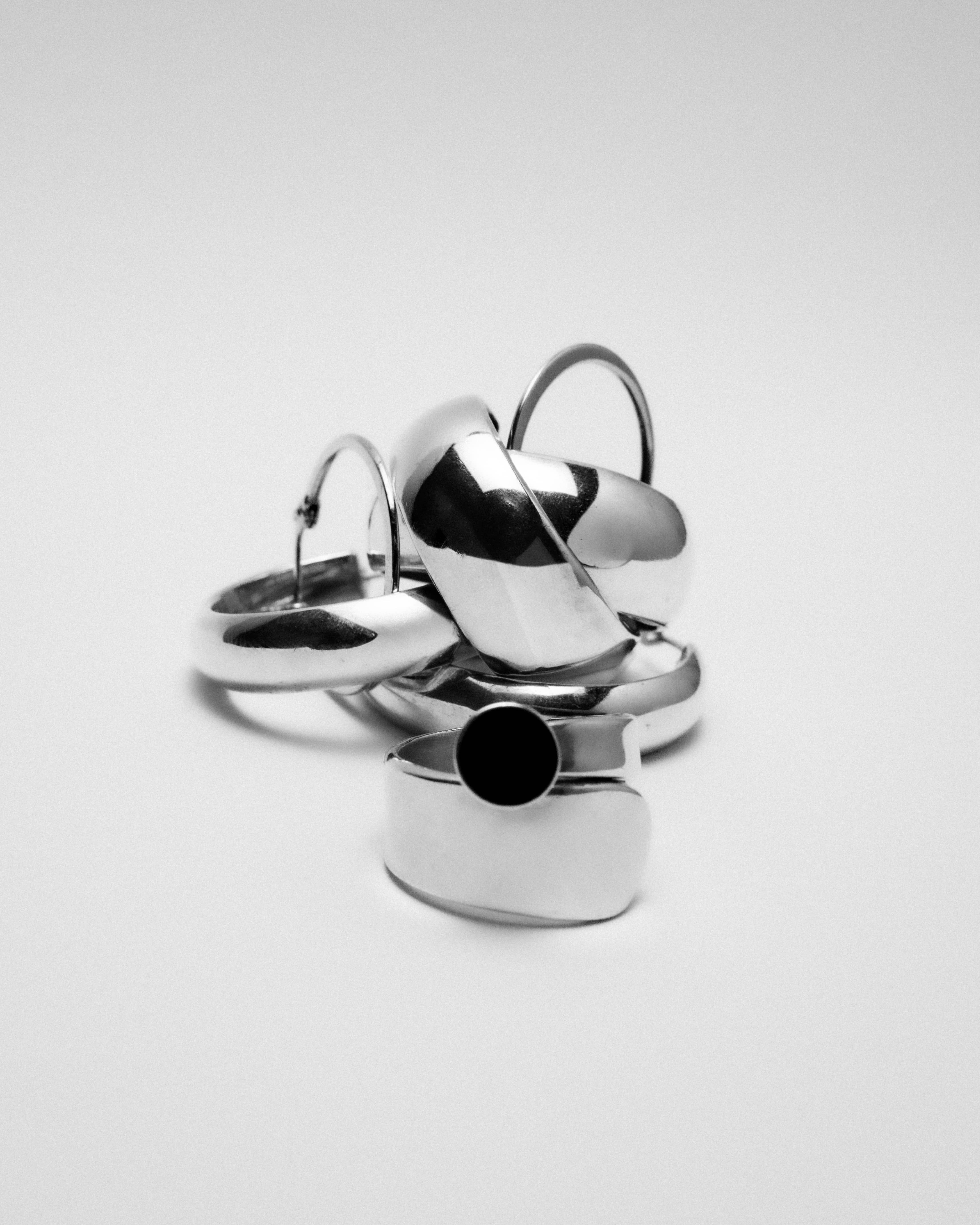 Styled photo of silver jewelry against a white background.
