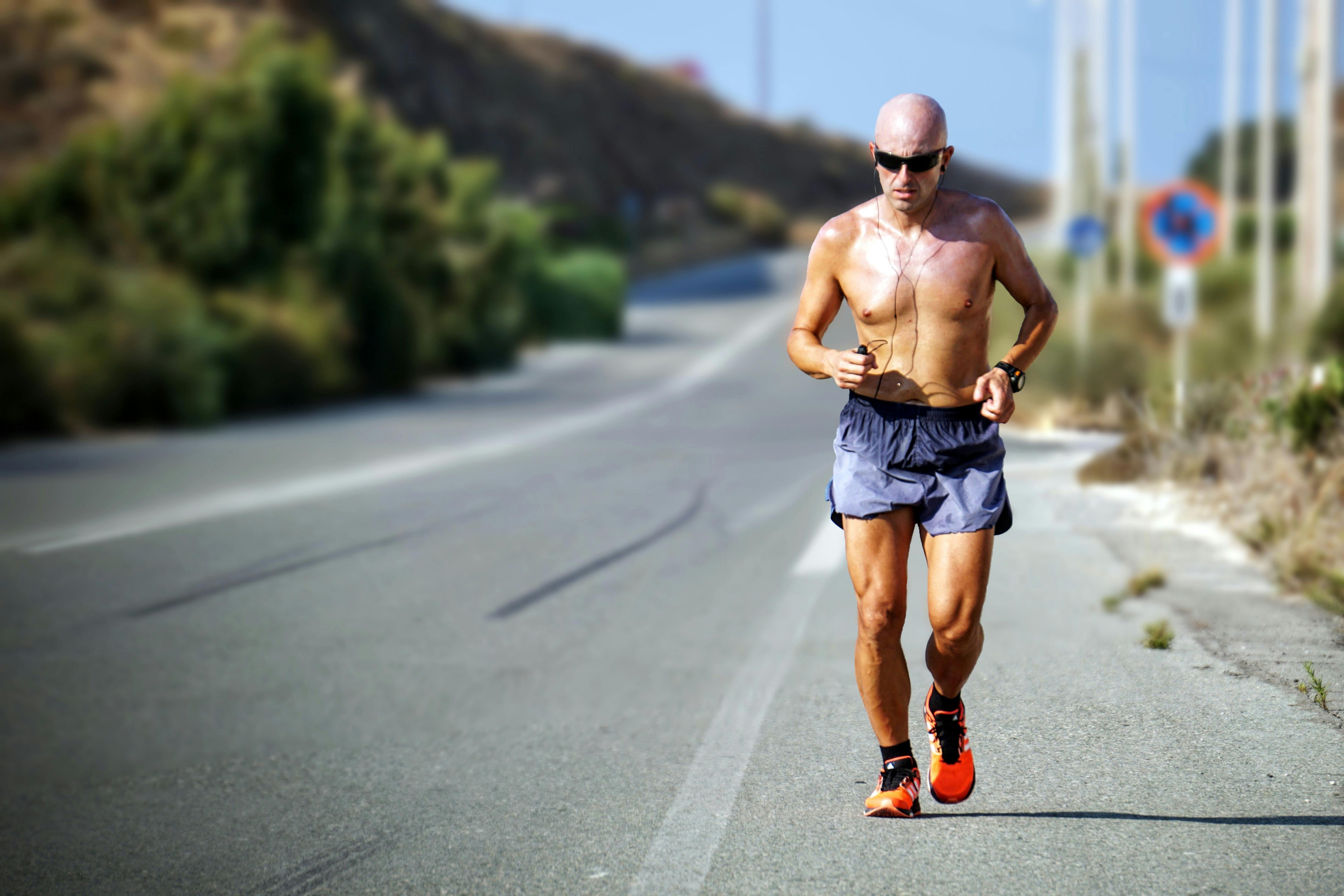 Runner holding their shin, illustrating discomfort from medial tibial stress syndrome (shin splints).