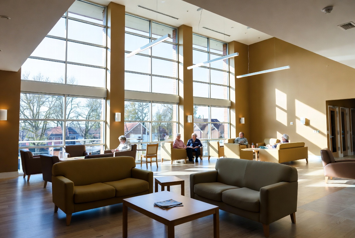 Modern Texas assisted living community common area with residents relaxing and energy-efficient lighting and HVAC – helping senior living facilities reduce electricity costs in 2026