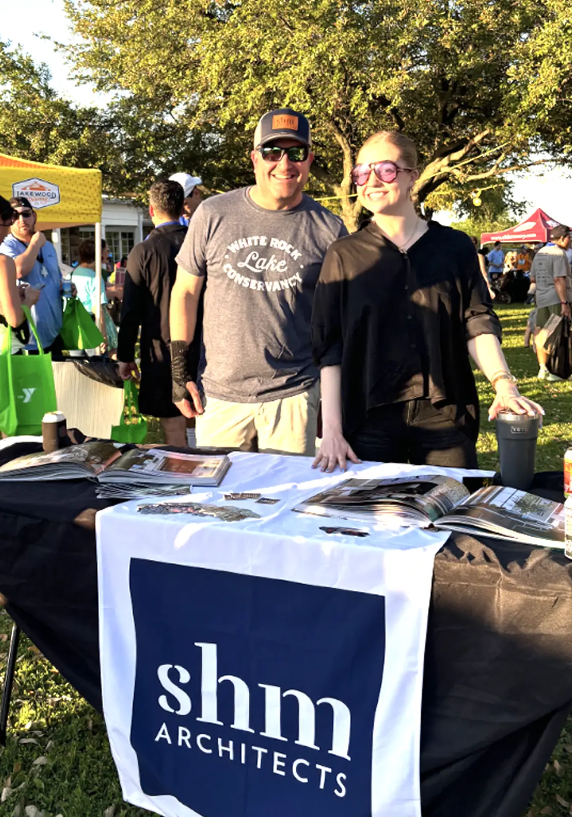 Two smiling people standing behind a table Celebration White Rock race in Dallas, TX.