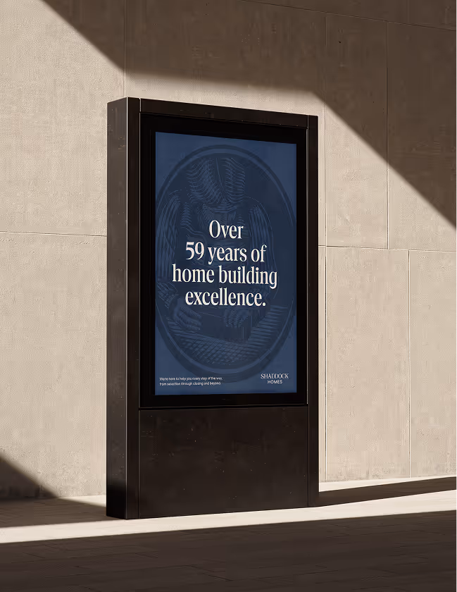 Outdoor digital sign with text reading 'Over 59 years of home building excellence' against a stone wall background.
