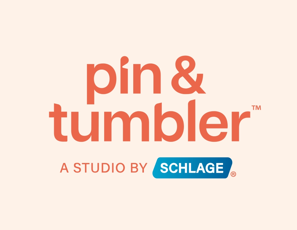Logo of pin & tumbler, a studio by Schlage, with text in orange and blue on a peachy background.