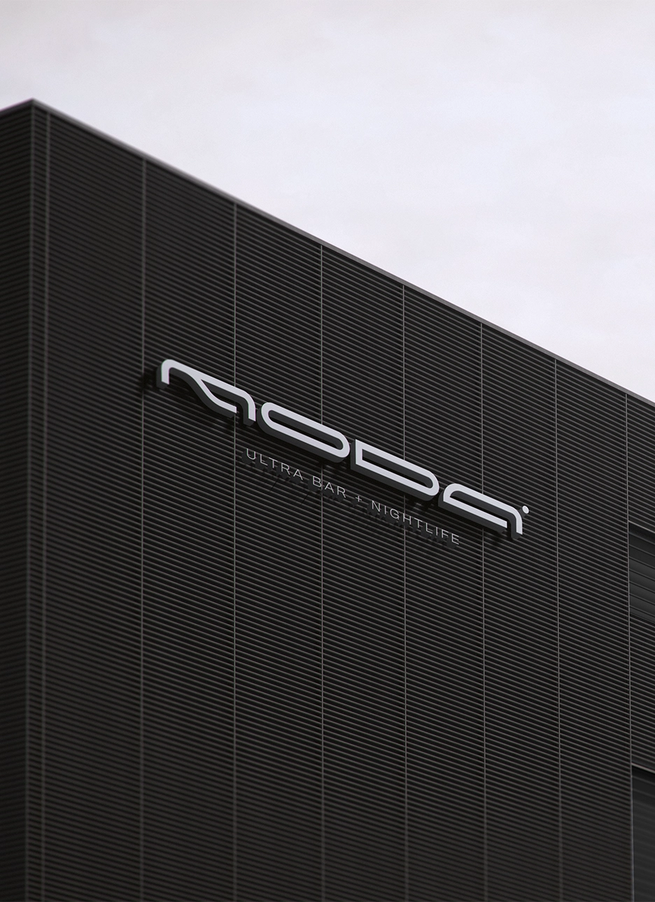 Modern industrial building facade with horizontal black slats and a sign reading 'MODA ULTRA BAR + NIGHTLIFE' against an overcast sky.