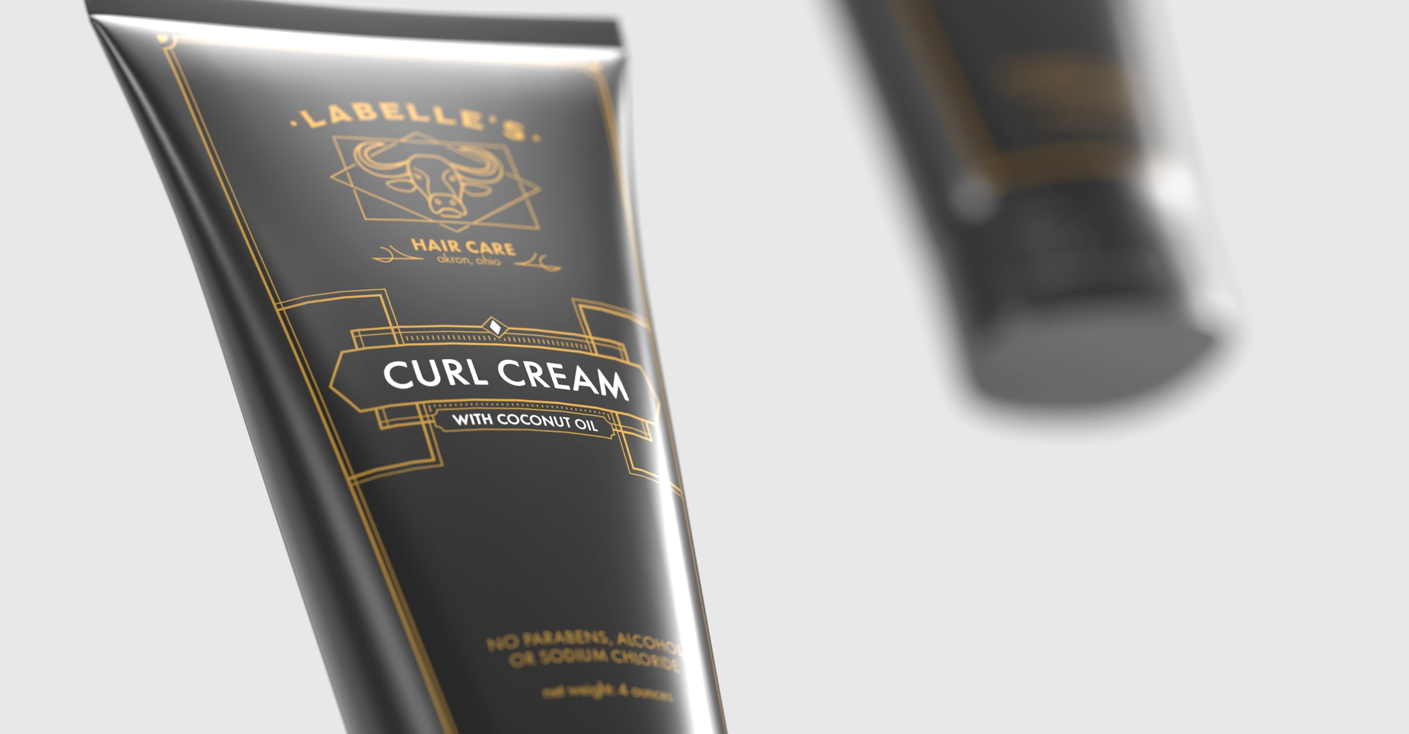 Floating black tubes of LaBelle's Curl Cream hair care product with coconut oil and gold decorative text and accents.