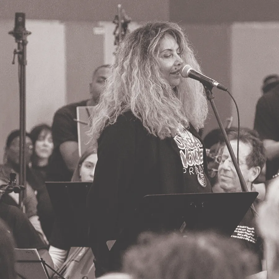 Singer performing with a choir behind her