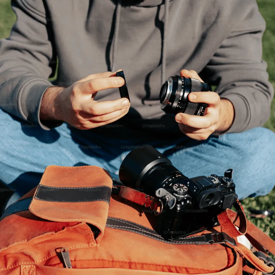 Person holding a camera while sitting on grass
