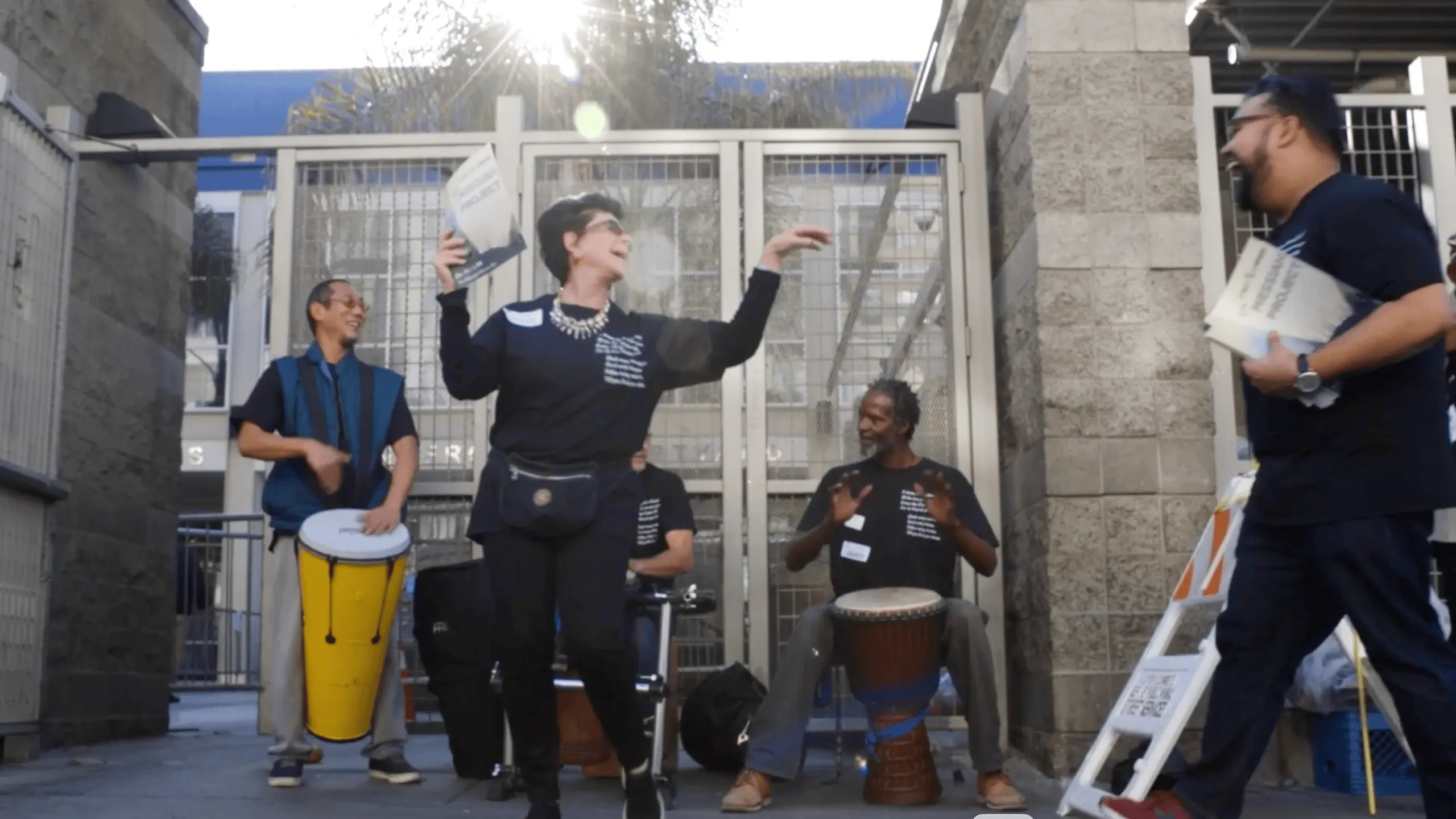 Group of musicians and participants performing in an outdoor courtyard