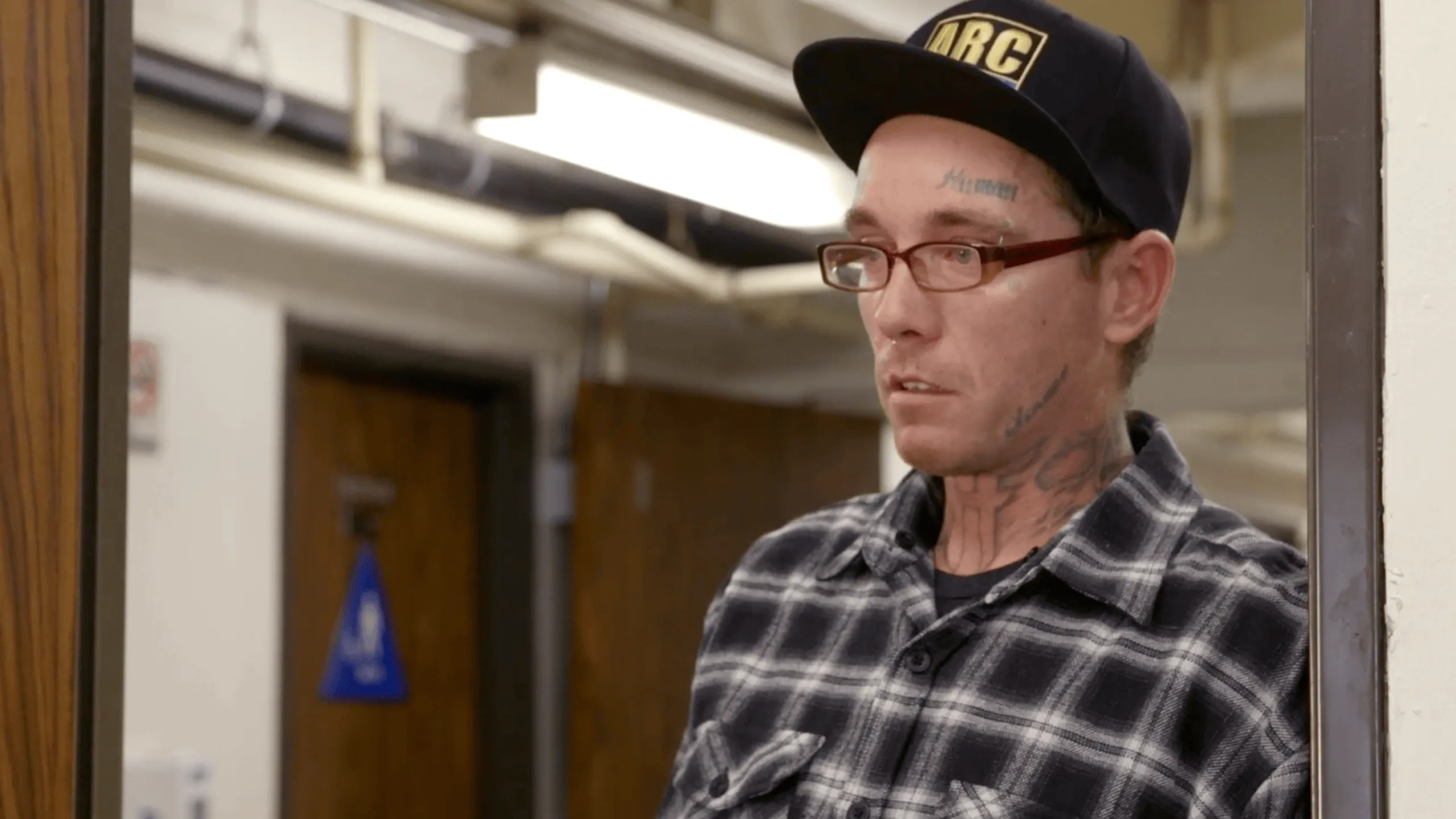 Man wearing a cap speaking indoors during an interview