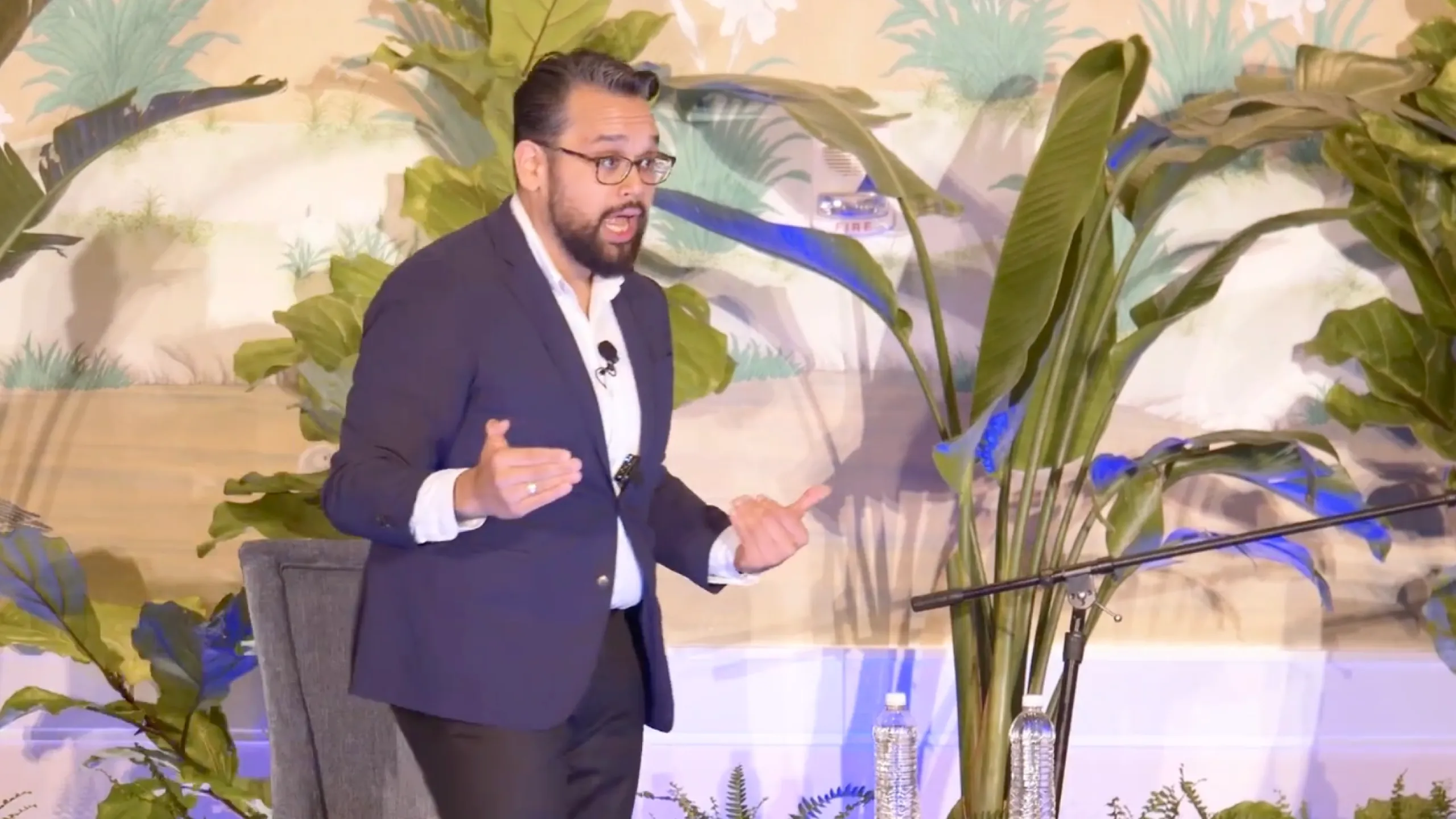 Vijay Gupta speaking into a microphone during a presentation