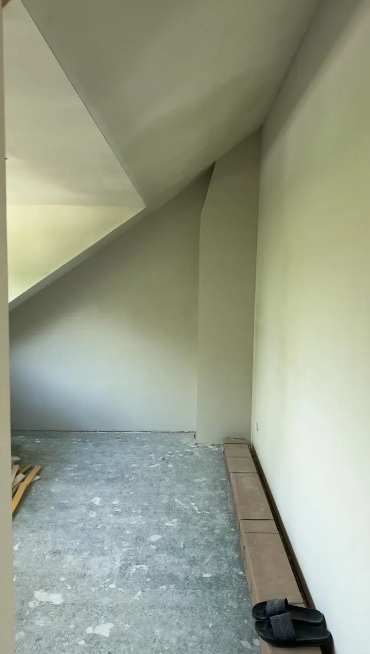 Onafgewerkte ruimte met schuin plafond en muren klaar voor professioneel stucwerk en afwerking
