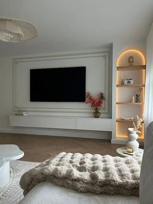Moderne woonkamer met glad stucwerk, zwevend wit meubel, verlichte boogvormige nissen met decoratie
