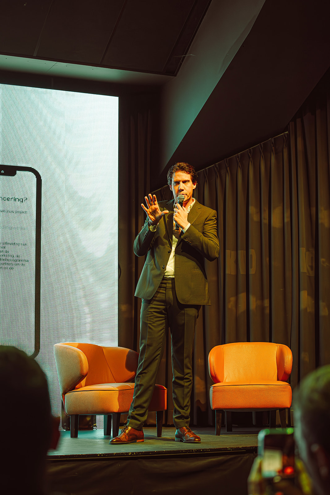Spreker Gilles Bonvin op het podium tijdens een keynote over bedrijfsstrategie en groeiversnelling.