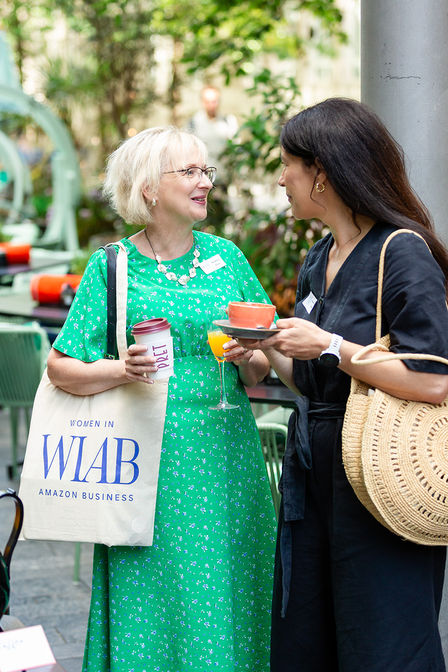 Diverse group of people seated indoors attentively listening at a conference or seminar.