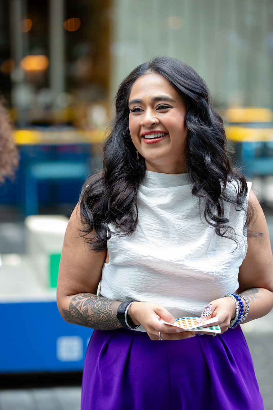 Five women seated indoors, two holding microphones, engaged in a discussion during a panel event.