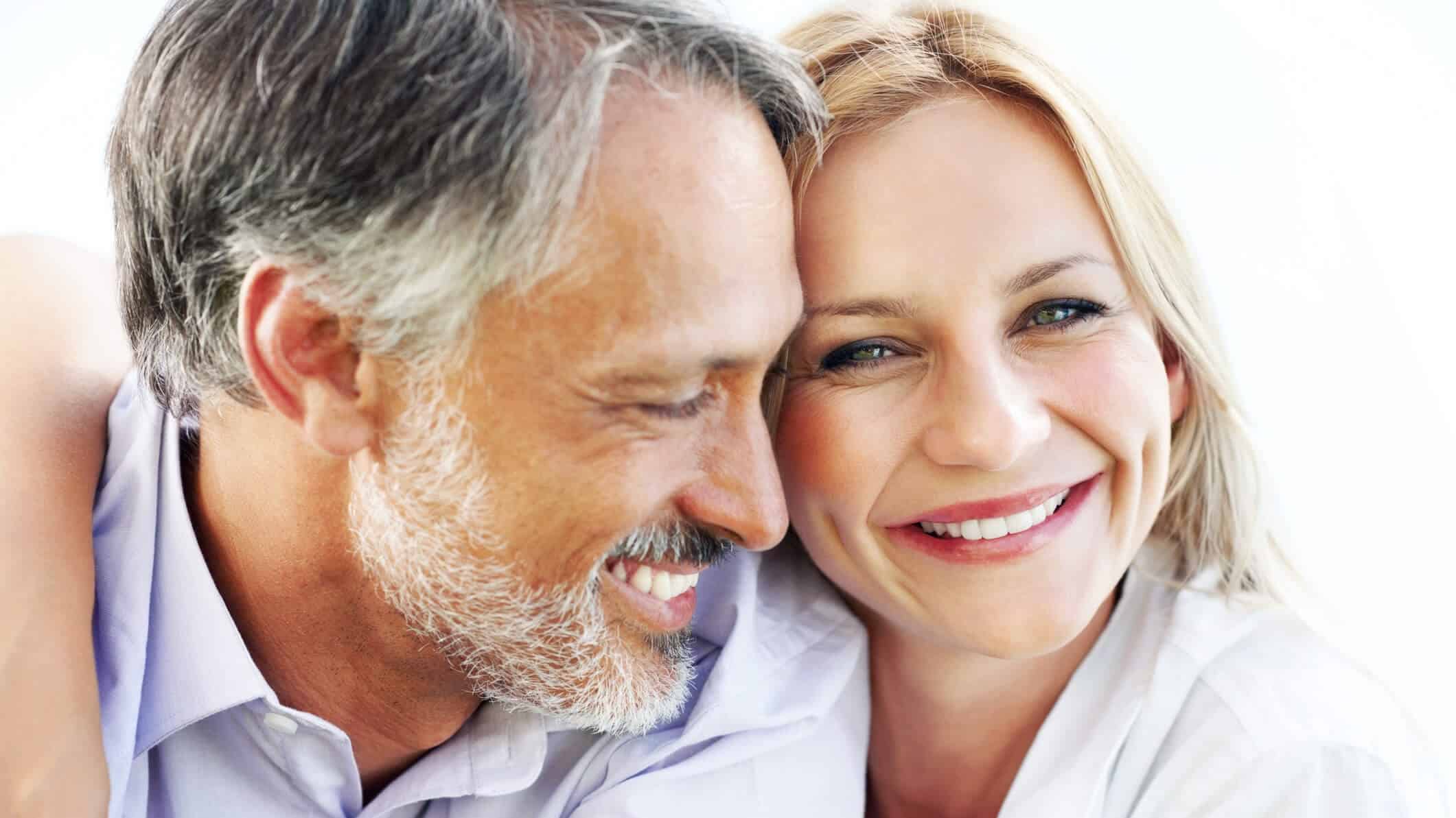 Happy middle-aged couple smiling and embracing, symbolizing relationship confidence post erectile dysfunction treatment.