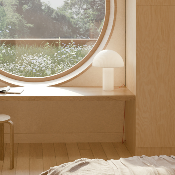 Minimalist bedroom with light wood paneling, a round window with a scenic view, a wooden desk, a stool, and a small modern lamp.