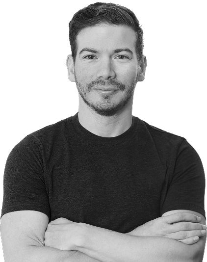 Man with short hair and light beard wearing a dark t-shirt with arms crossed, smiling slightly.