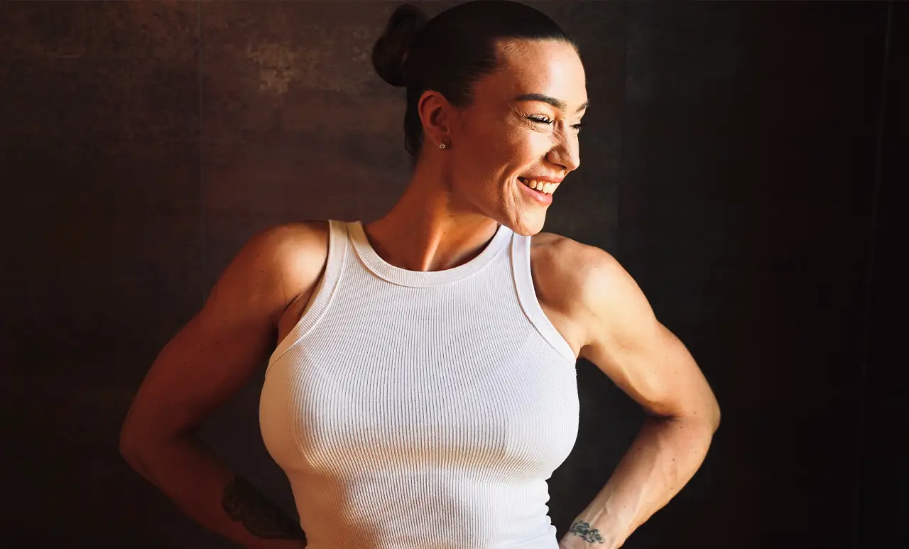 Anna lächelt selbstbewusst in einem weißen Top – das Bild steht für mentale Stärke, Klarheit und innere Balance, wie sie das Anatomie Workbook vermittelt.