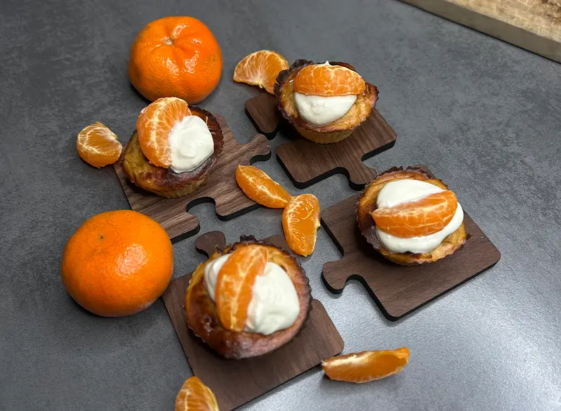 Fruchtige Mini-Mandarinen-Törtchen mit cremigem Topping – süße, leichte Dessertidee aus dem Anatomie Kochbuch.