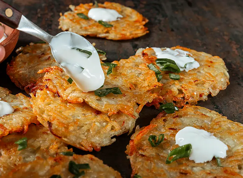 Knusprige Kartoffelpuffer mit Kräuterquark – herzhafte Mahlzeit aus dem Anatomie Journal.