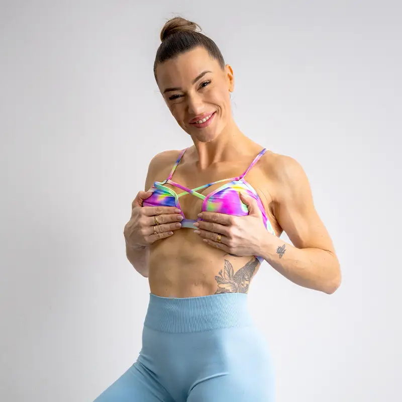 Anna Hahn lächelt im farbenfrohen Sport-Bikini und zeigt selbstbewusst ihren Körper – Symbol für Stärke, Lebensfreude und Freiheit.