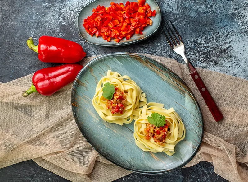 Tagliatelle Pasta mit frischer Paprika und Kräutern, stilvoll angerichtet – Anatomie Kitchen Around the World Rezept