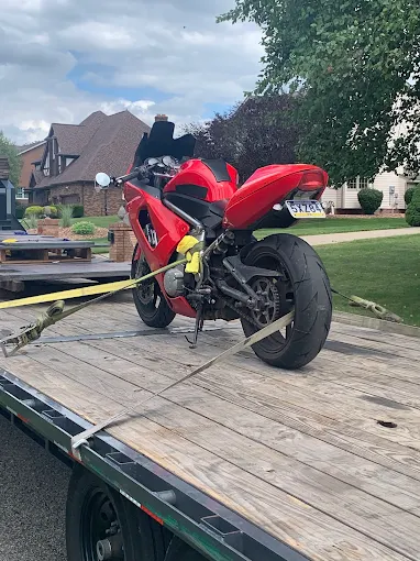 Ultimate Transport 123 Red motorcycle secured on flatbed trailer for transport. nationwide across the U.S.