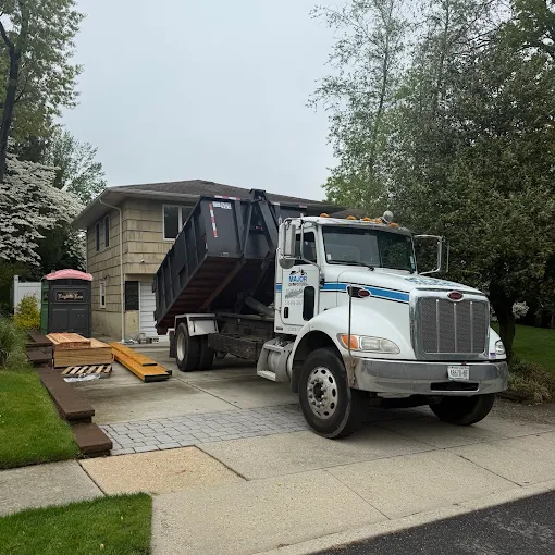 White dump truck with raised dumpster in driveway - Major Dumpsters Inc., Long Island