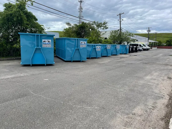 Major Dumpsters Inc.: Row of blue dumpsters in paved parking lot