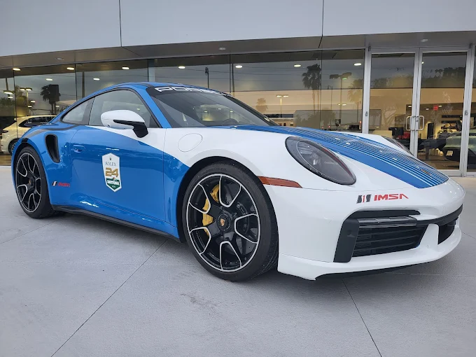 Ultimate Transport 123: Porsche 911 race car with blue and white livery at dealership