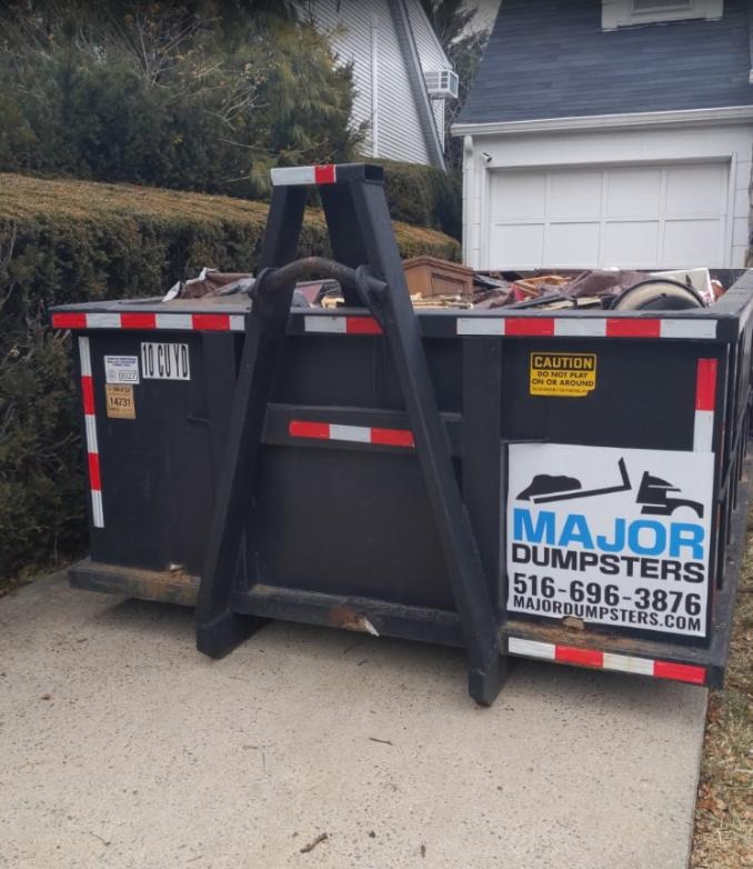 Major Dumpsters Inc.: Dumpster rental container on residential driveway with debris