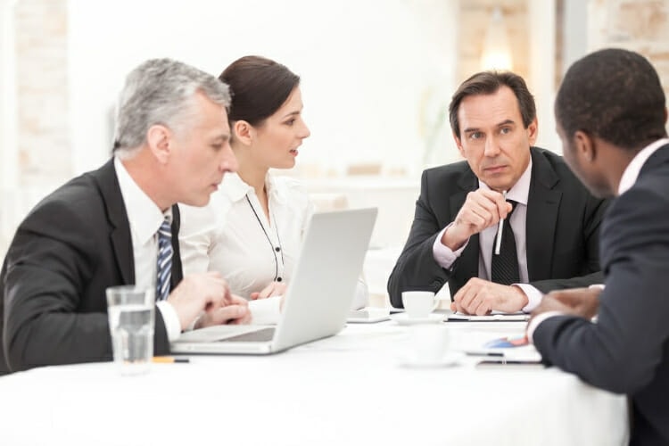 Four business professionals in formal meeting discussion - Matthew Fornaro, P.A., South Florida