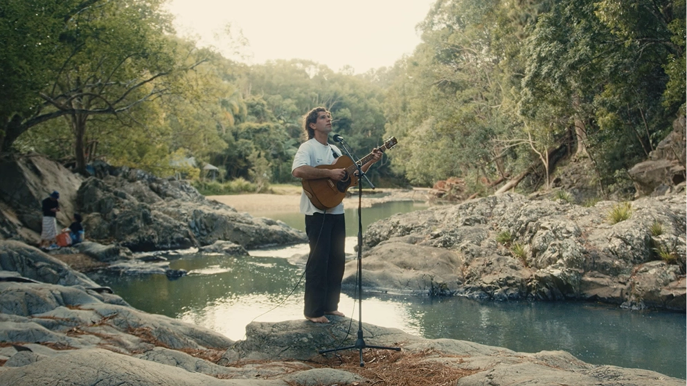 Gaudion performing “Gold” with an acoustic guitar at Currumbin Rock Pools