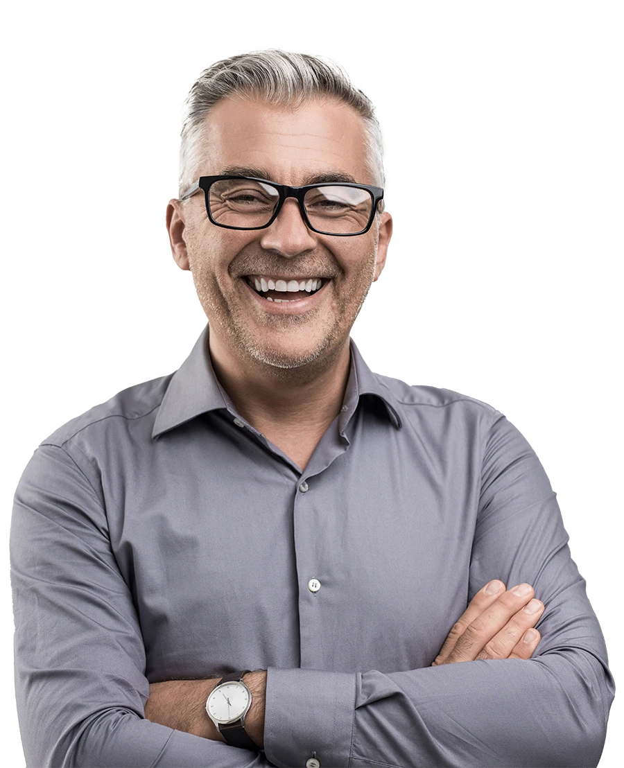 Smiling older man with gray hair and glasses wearing a gray shirt with arms crossed.