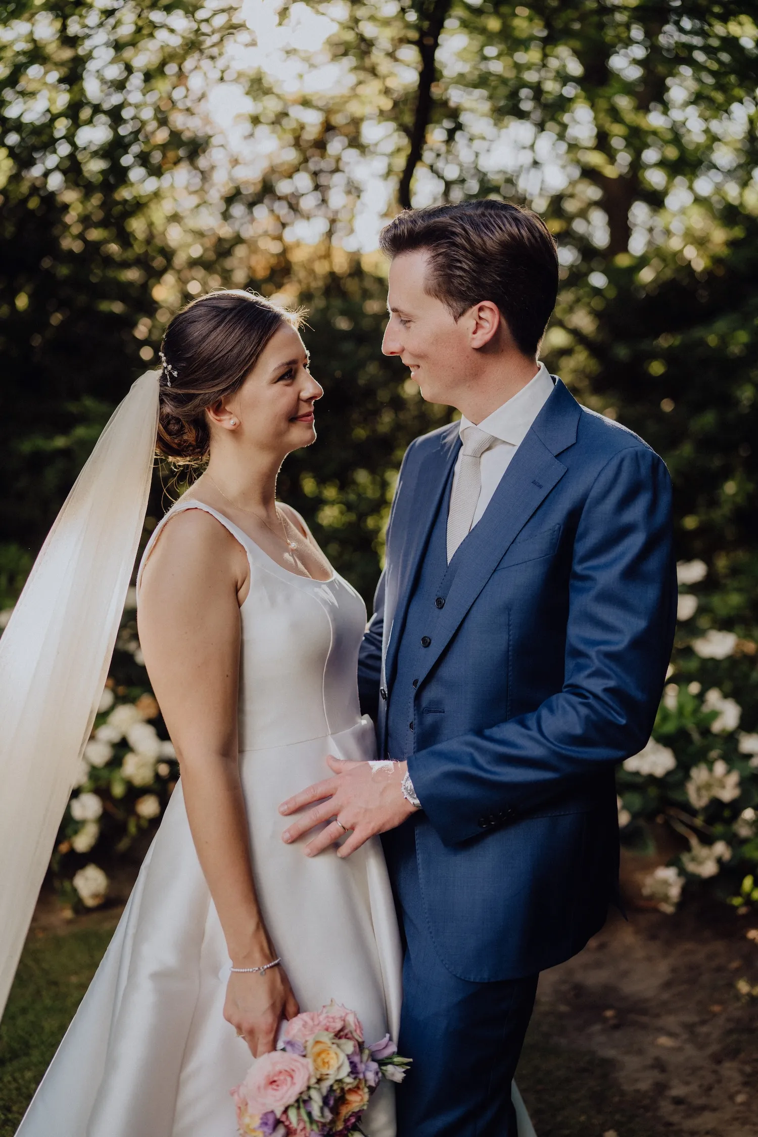 Paar trägt herzförmige Sonnenbrillen bei einer Feier, beide lächeln und haben die Arme ausgebreitet.