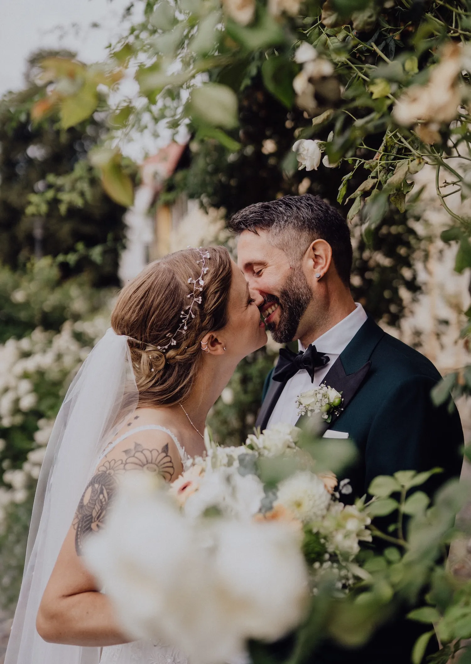 Brautschuh, Parfümflasche mit goldenem Deckel und goldene Schmuckbox auf weißem Stoff bei einer Hochzeit.
