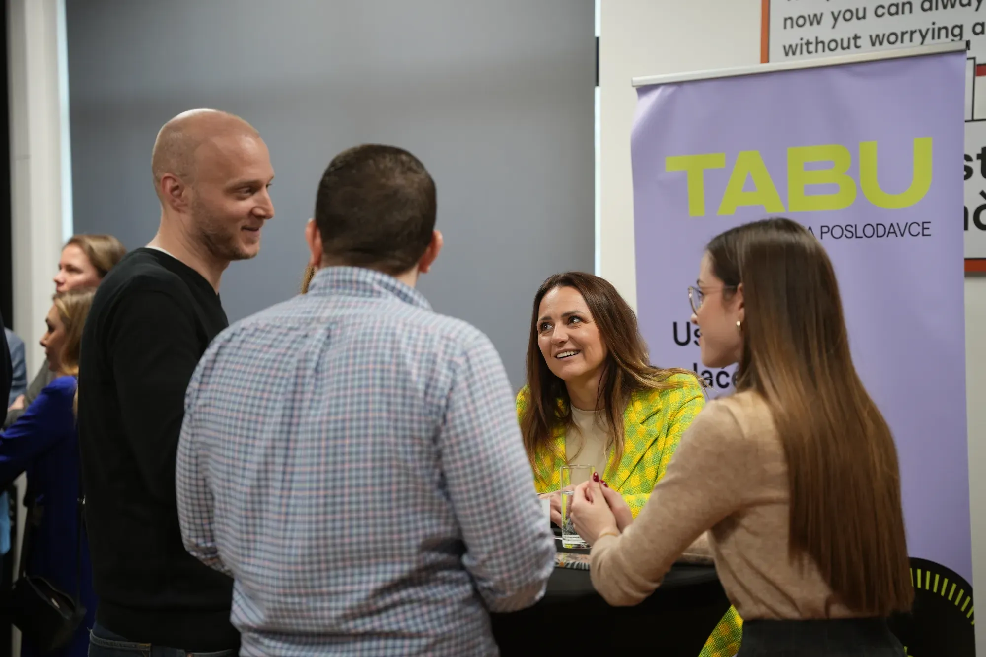 Sudionici Tabu eventa razgovaraju za stolom uz Tabu roll-up