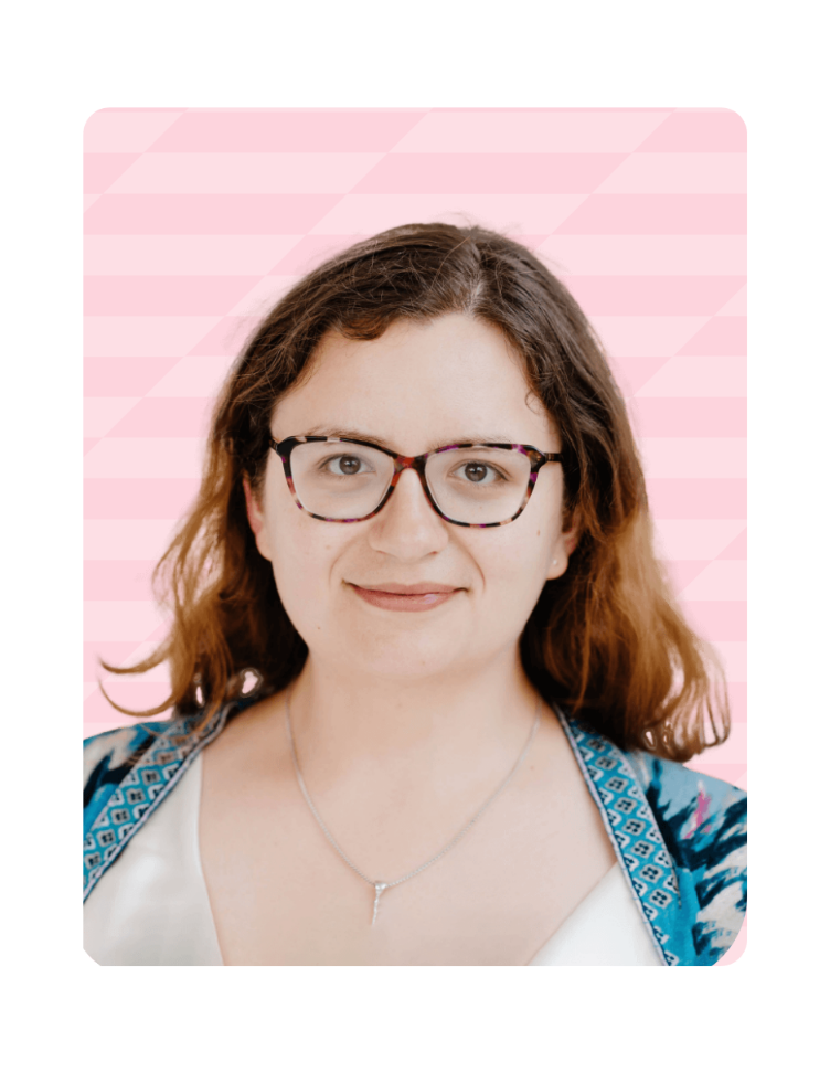 Two men shaking hands during a social interaction, one wearing a blue and green patterned scarf and glasses.